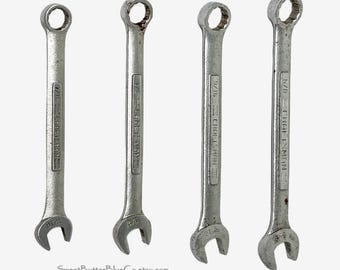 May include: A set of four silver-colored metal Craftsman combination wrenches arranged vertically. Each tool features an open-end on one side and a box-end on the other, with sizes 7/16, 1/2, 9/16, and 5/8 inches clearly stamped on the shafts.