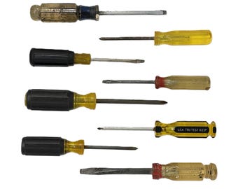 May include: A collection of eight assorted manual screwdrivers with varying handle colors including yellow, black, and clear plastic. The metal shafts are silver-toned. One yellow handle features the printed text U.S.A. TRU-TEST 633P on its side.