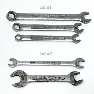 May include: Five silver-toned metal Craftsman wrenches arranged in two groups labeled Lot #1 and Lot #2. The top three are combination wrenches with box and open ends. The bottom two are double open-ended wrenches with various sizes marked.