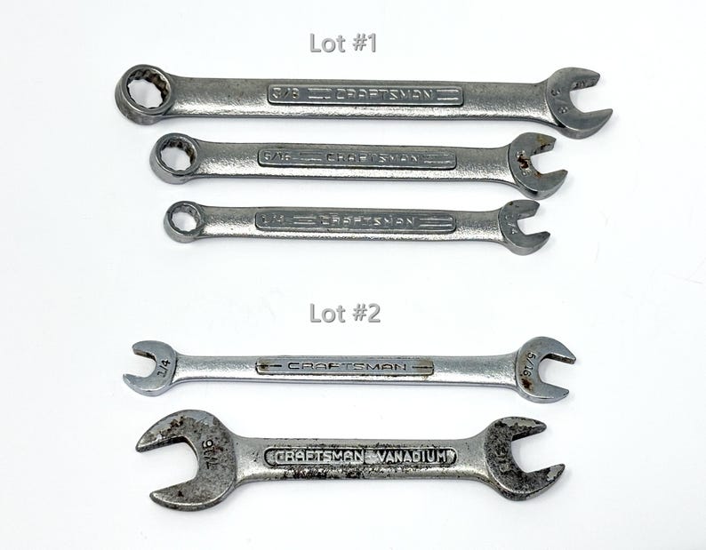 May include: Five silver-toned metal Craftsman wrenches arranged in two groups labeled Lot #1 and Lot #2. The top three are combination wrenches with box and open ends. The bottom two are double open-ended wrenches with various sizes marked.