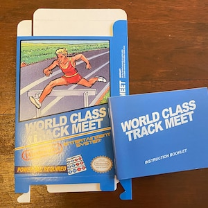 Może przedstawiać: Niebieskie i białe pudełko gry Nintendo Entertainment System do gry World Class Track Meet. Pudełko zawiera ilustrację biegacza skaczącego przez przeszkodę. Widoczna jest również instrukcja obsługi.