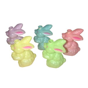 Peut inclure: Cinq bougeoirs en forme de lapin de Pâques en plastique de couleur pastel. Les lapins sont dans des tons de rose, bleu, jaune et vert.