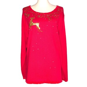 May include: A red long-sleeved sweater with a gold reindeer and gold glitter design.