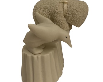 May include: A white ceramic figurine of a penguin standing on a tree stump with a white ceramic bear leaning over the penguin.