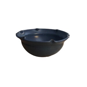 May include: A small, dark blue ceramic bowl with a scalloped rim.