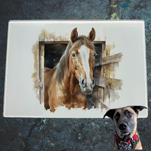 Peut inclure: Planche à découper en verre rectangulaire avec une peinture à l'aquarelle d'un cheval brun avec une liste blanche, regardant par une porte de grange en bois. Le cheval a une longue crinière. Un chien avec un bandana rouge est dans le coin inférieur droit.