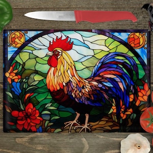 Puede incluir: Una tabla de cortar de vidrio coloreado con un gallo colorido con cresta y barbillas rojas. El gallo está de pie en un campo verde con flores y un cielo azul en el fondo.