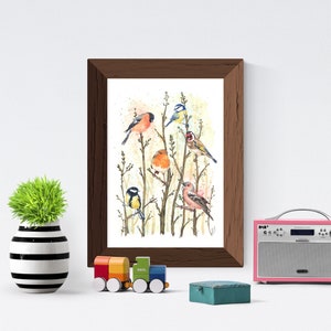 May include: A framed watercolor print featuring several colorful birds perched on branches. The artwork is in a dark brown frame and is displayed on a white wall. A small, decorative green plant in a black and white striped vase, a toy train, and a pink radio are also visible.