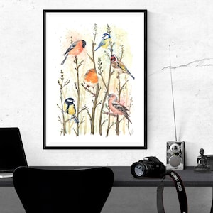 May include: A framed watercolor print featuring seven colorful birds perched on branches. The birds include a robin, a blue tit, a bullfinch, and a goldfinch, set against a soft, abstract background. The artwork is displayed on a desk with a laptop and camera.