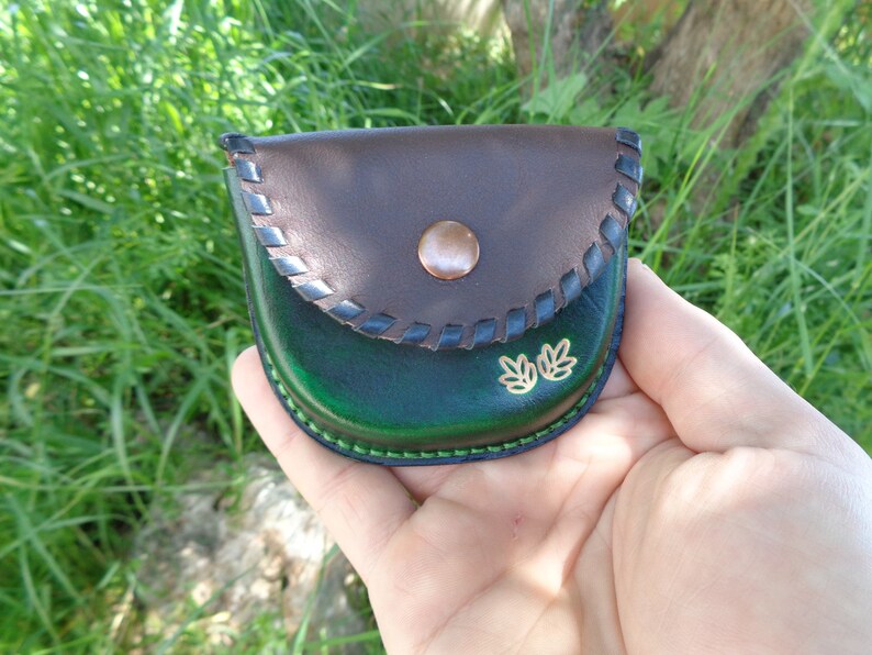 Monedero de cuero verde con solapa marrón y cierre de broche