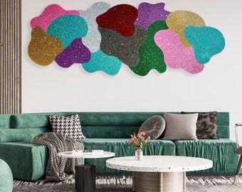 May include: A modern living room interior with a green sofa, a round coffee table, and a large abstract wall art piece made of colorful, glittery shapes.
