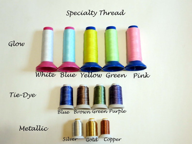 May include: A collection of specialty threads in various colors, including white, blue, yellow, green, and pink, with the text "Glow." Additional threads are labeled "Tie-Dye" and "Metallic," with colors like silver, gold, and copper.