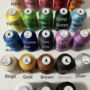 May include: A collection of colorful embroidery thread spools. The image displays a variety of colors, including red, orange, yellow, green, blue, purple, brown, and gray. The text at the top reads "Basic colors-- More colors available by request."