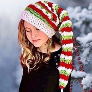 May include: A white, red and green striped crocheted elf hat with a long, pointed tip and a white pom-pom at the end.