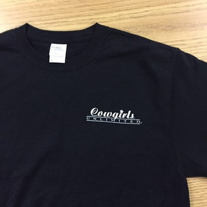 May include: Black t-shirt with a white graphic that says "Cowgirls Unlimited".