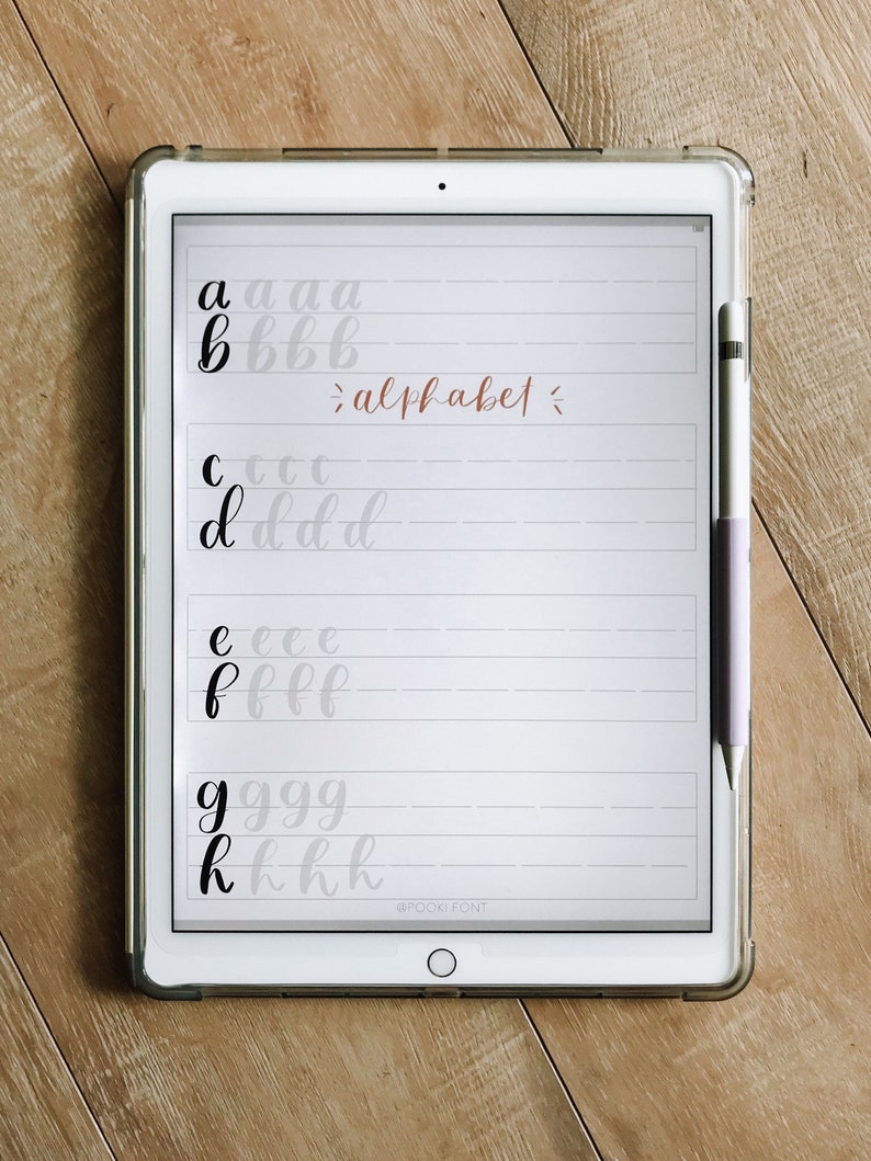 May include: A digital tablet screen displaying a handwritten alphabet in black ink on a white background. The letters are written in cursive and are spaced out evenly. The text "alphabet" is written in cursive in a light brown color. The text "@POCKY FONT" is written in black at the bottom of the screen.