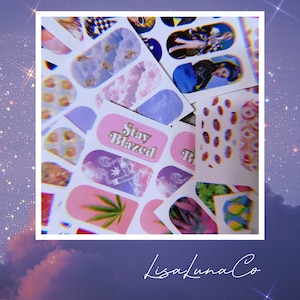 May include: Assortment of colorful nail art stickers featuring various designs, including clouds, marijuana leaves, and the text "Stay Blazed".