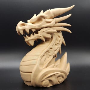 May include: A detailed, beige-colored dragon sculpture. The dragon has sharp teeth, horns, and intricate scale detailing. The sculpture is posed in a curved position, with its head raised and mouth open, showcasing a fantasy theme.