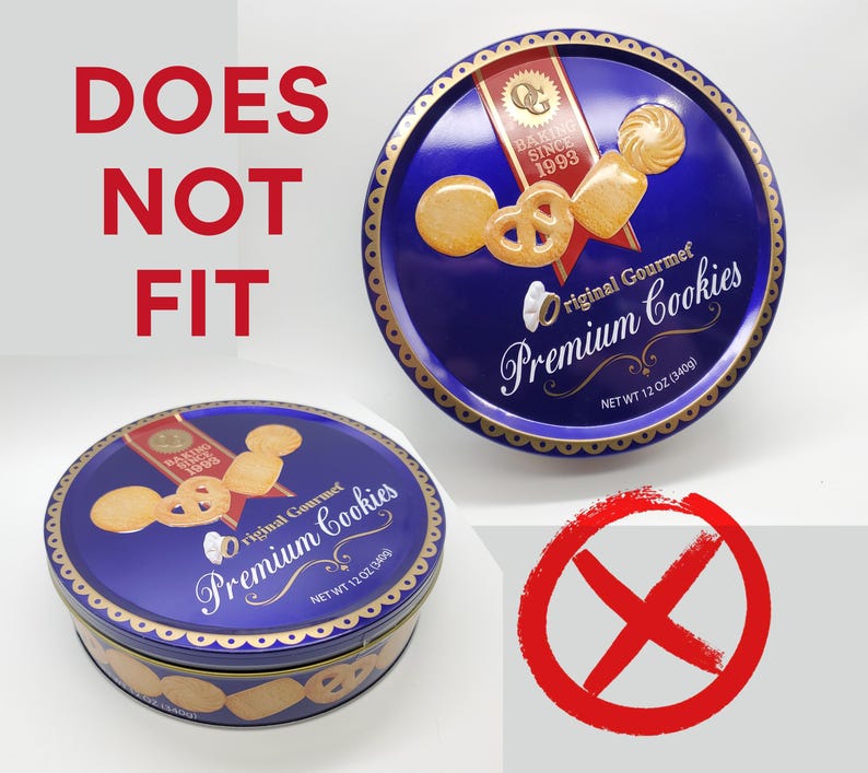 May include: Two blue cookie tins with gold trim and the words "Premium Cookies." One tin is open, displaying cookies. The text "DOES NOT FIT" is above the tins, with a red "X" symbol.