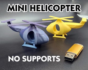 May include: Two miniature 3D-printed helicopters, one purple and blue, the other yellow, with a gold USB drive. The text "MINI HELICOPTER" and "NO SUPPORTS" are displayed in white. The helicopters have a rounded fuselage and rotor blades.