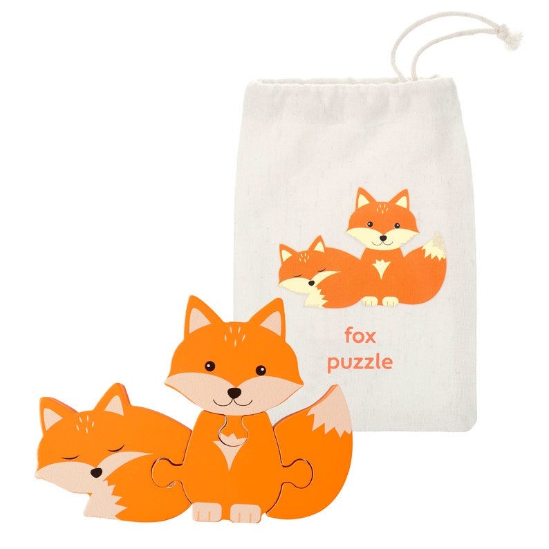May include: A wooden fox puzzle with three pieces. The puzzle is orange and has a cute cartoon fox design. The puzzle comes in a small canvas bag with a fox design and the text "fox puzzle".