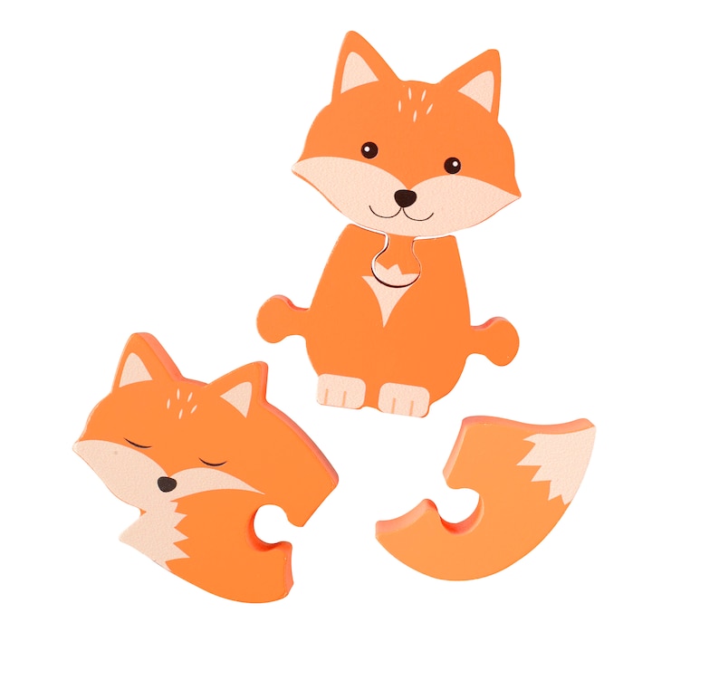 May include: Orange wooden puzzle with three pieces that form a fox. The fox has a white belly and a black nose.