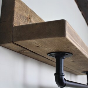 Pu&ograve; includere: Un ripiano in legno rustico con staffe in tubo metallico nero. Il ripiano &egrave; realizzato in legno riciclato e ha una finitura naturale. Le staffe sono in stile industriale e aggiungono un tocco moderno al ripiano.