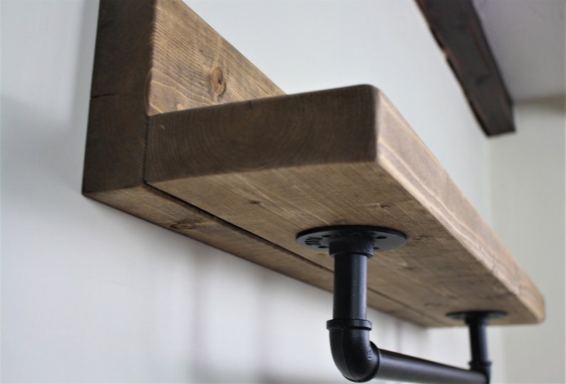 Pu&ograve; includere: Un ripiano in legno rustico con staffe in tubo metallico nero. Il ripiano &egrave; realizzato in legno riciclato e ha una finitura naturale. Le staffe sono in stile industriale e aggiungono un tocco moderno al ripiano.