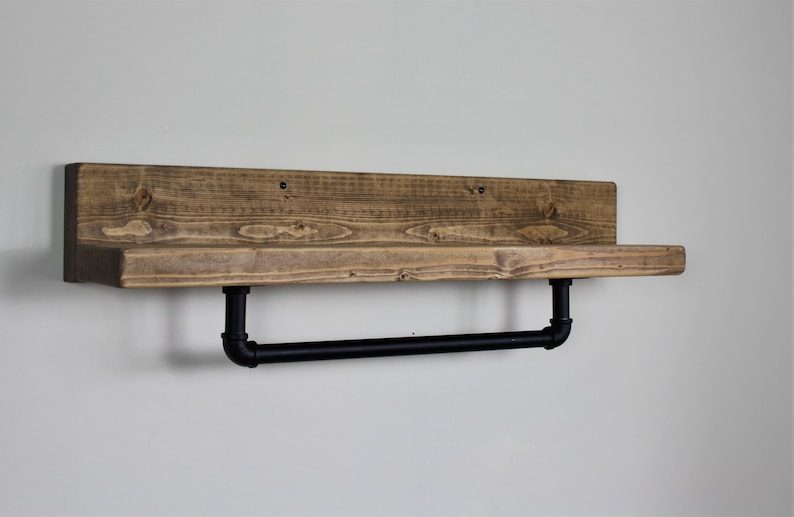 Pu&ograve; includere: Un ripiano in legno rustico con una barra porta asciugamani in metallo nero. Il ripiano &egrave; realizzato in legno riciclato e ha una finitura naturale. La barra porta asciugamani &egrave; fissata al ripiano con due tubi in metallo nero.