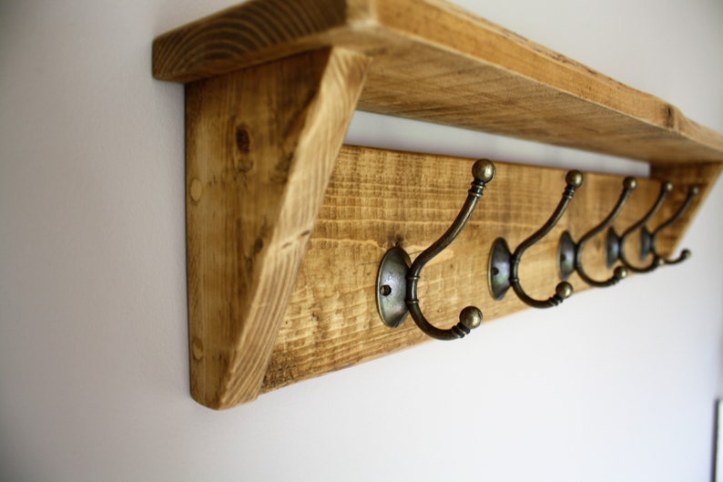Peut inclure: &Eacute;tag&egrave;re en bois rustique avec un porte-manteau comprenant six crochets en laiton antique. L'&eacute;tag&egrave;re est en bois de r&eacute;cup&eacute;ration et a une finition naturelle.