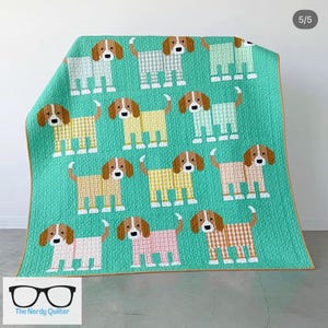 May include: A quilted blanket featuring a repeating pattern of cartoon dogs in various pastel colors, including yellow, pink, and green, set against a teal background. The dogs have brown ears and tails, and are wearing gingham pajamas. The Nerdy Quilter logo is in the bottom left corner.