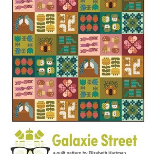 May include: A quilt pattern titled Galaxie Street by Elizabeth Hartman, featuring a grid of colorful blocks with motifs of mushrooms, flowers, houses, strawberries, apples, and birds in shades of green, pink, brown, and yellow, with a logo.