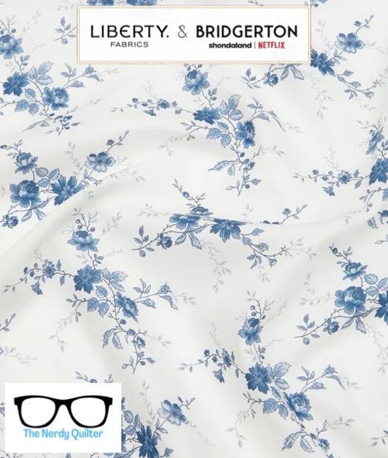 May include: White fabric with a blue floral pattern. The fabric features a repeating pattern of small blue flowers and leaves. The fabric is labeled "Liberty & Bridgerton Fabrics shondaland | NETFLIX".