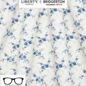 May include: White fabric with a blue floral pattern. The fabric has a small, delicate floral design with blue flowers and leaves. The fabric is perfect for quilting, sewing, and crafting.