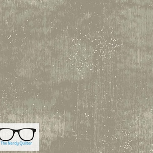 May include: A close-up of a textured fabric with a subtle green and white speckled pattern. The fabric has a slightly rough, almost sandpaper-like texture.