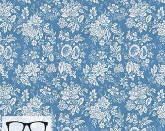 May include: A blue fabric with a white floral pattern. The fabric is a quilting cotton and has a repeating pattern of small and large flowers.