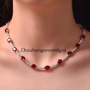 May include: A silver necklace featuring oval red gemstones and small, clear stones. The necklace is worn around the neck. The text "Chouhangemsmfgco" is visible on the image.