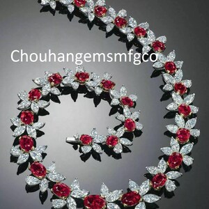 May include: A floral-inspired jewelry set featuring a necklace and bracelet. The set showcases oval-cut red gemstones surrounded by white, petal-shaped stones. The text "Chouhanggemsmfgco" is visible.
