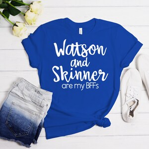 Könnte beinhalten: Ein königsblaues T-Shirt mit weißem Text, der "Watson and Skinner are my BFFs" lautet.