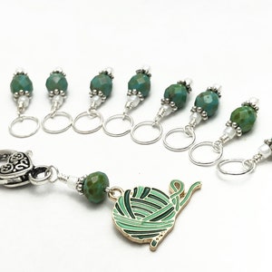 May include: Set of eight teal green and silver stitch markers with a silver heart-shaped clasp and a charm of a green yarn ball.