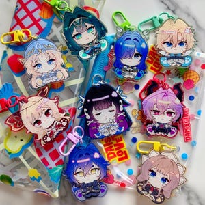 Puede incluir: Una colección de llaveros de personajes de estilo anime con varios colores de pelo y atuendos. Cada llavero tiene un diseño colorido, un cierre de metal y un respaldo de plástico transparente. Los llaveros se muestran en una bolsa transparente con detalles coloridos.