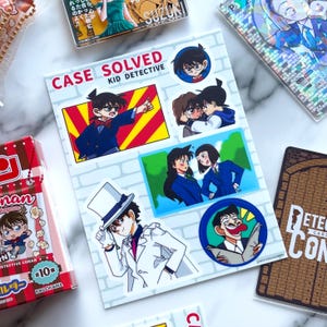 Puede incluir: Una hoja de pegatinas con personajes de la serie de anime "Case Closed" o "Detective Conan". Las pegatinas muestran varias escenas y personajes, incluyendo un detective con traje azul y un personaje con traje blanco. El texto "CASE SOLVED KID DETECTIVE" es visible.