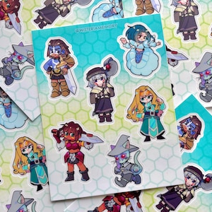 May include: A sheet of stickers featuring various cartoon characters in fantasy attire. The stickers include characters with swords, axes, and magical accessories. The background of the sticker sheet is a gradient of blue and green with a honeycomb pattern.