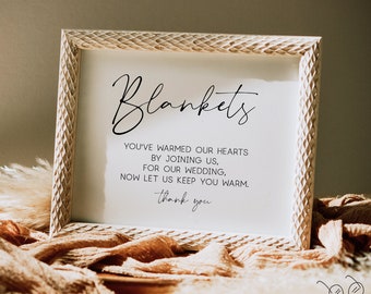May include: A framed sign with the word "Blankets" in elegant script. The sign includes text that reads "You've warmed our hearts by joining us, for our wedding, now let us keep you warm. Thank you." The frame has a textured, carved design.