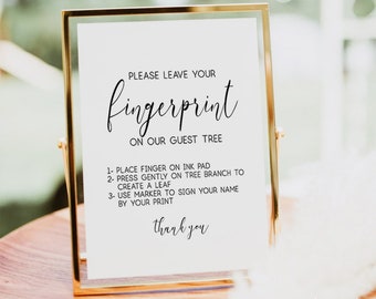 May include: A white sign in a gold frame with the text "Please leave your fingerprint on our guest tree".  Instructions are listed below: 1. Place finger on ink pad, 2. Press gently on tree branch to create a leaf, 3. Use marker to sign your name by your print. The sign also says "thank you".