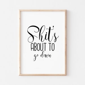 May include: A framed print with the text "Shit's about to go down" in a black cursive font.
