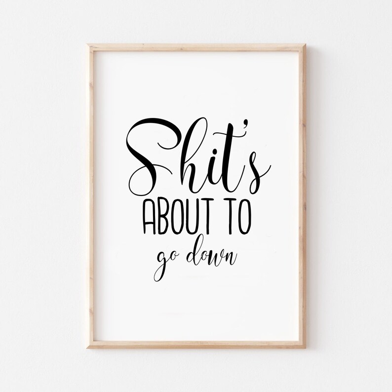 May include: A framed print with the text "Shit's about to go down" in a black cursive font.