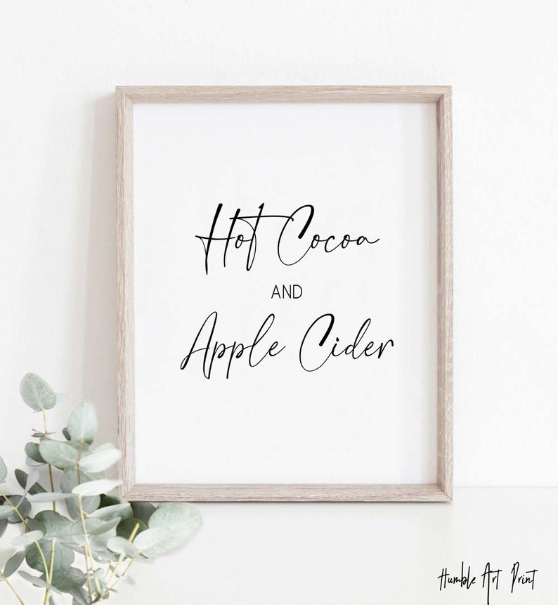 May include: A framed print with the text "Hot Cocoa and Apple Cider" in black cursive script on a white background.