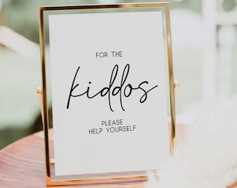 May include: A gold-framed sign with white background and black text that reads "For the kiddos. Please help yourself."