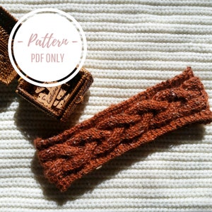 Puede incluir: Una diadema de punto marrón con un patrón de punto trenzado. La diadema está sobre una superficie de punto blanco. El texto "Pattern - PDF ONLY" es visible en un círculo.